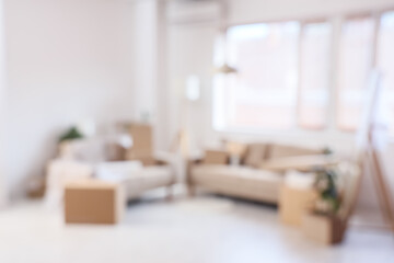 Blurred view of sofas with cardboard boxes in light room on moving day