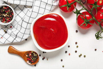 Bowl of tasty ketchup with peppercorns and tomatoes on white background