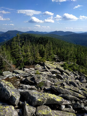 Mountain landscape view from the summit with large rocks in the foreground. Vertical photo