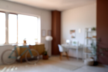 Blurred view of home office with workplace, bicycle and commode