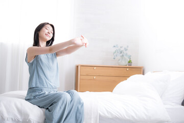 The whole body of the video of a woman stretching and lying on the bed, stretching and waking up in...