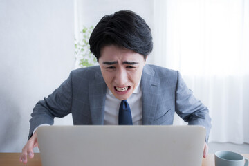 パソコンを見る 仕事で失敗やタスクや納期を忘れて困るビジネスマン