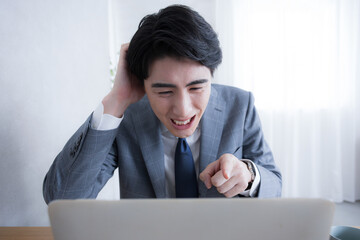 パソコンを見る失敗やタスクや納期を忘れて困るビジネスマン