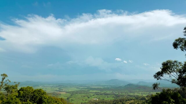 High watching over the valley with big storm clouds in the distance rolling over the hills.