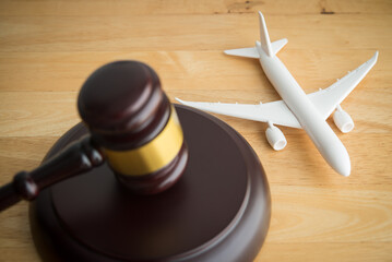 Judge hammer gavel and airplane on wooden table background. International Air Law (IAL), aviation law concept.