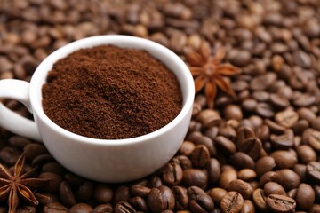 Cup with instant coffee powder and star anise on beans, closeup