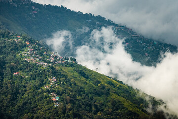Misty Mountain Town with Lush Green Hills and Clouds in a Scenic Valley Landscape
