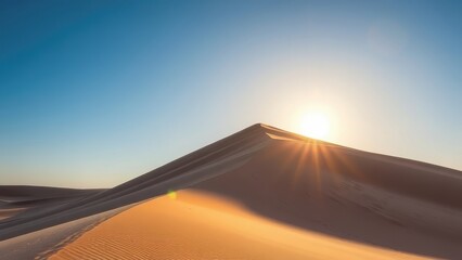 Desert landscape with sand dunes and sun against clear blue sky, golden light