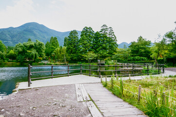 Scenic Park with Pond, Walkways, and Mountains : A beautiful view of a park with a calm pond,...