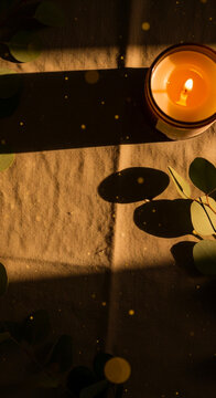 Minimal Flat Lay Candle with Eucalyptus on Neutral Linen Bokeh Lights &ndash; Warm Boho Calm Mood Vertical