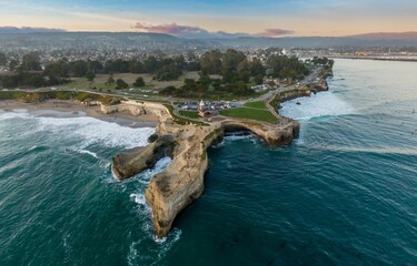 Aerial view of people surfing and enjoying the beach at Natural Bridges State Beach in Santa Cruz,...