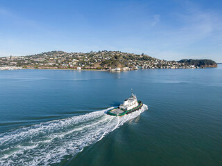 A tugboat navigates the calm waters of the San Francisco Bay in California, USA. The vessel is...