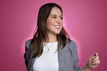 Confident young woman in modern studio portrait with pink background