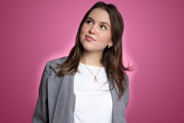 Fototapeta premium Confident young woman in modern studio portrait with pink background