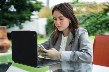 Young woman working remotely with tablet and smartphone outdoors