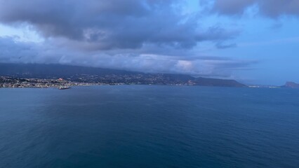 A tranquil coastline view at dusk with calm waters and cloudy skies, perfect for relaxation and peace
