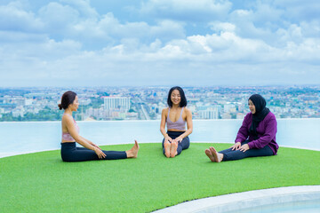 yoga, Asian woman wearing yoga clothes practicing yoga, Asia group of women exercising healthy lifestyle in outdoor fitness studio. swimming pool. Sport activity, gymnastics or ballet dancing class.