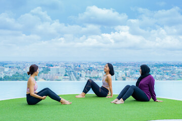 yoga, Asian woman wearing yoga clothes practicing yoga, Asia group of women exercising healthy lifestyle in outdoor fitness studio. swimming pool. Sport activity, gymnastics or ballet dancing class.