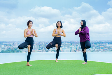 yoga, Asian woman wearing yoga clothes practicing yoga, Asia group of women exercising healthy lifestyle in outdoor fitness studio. swimming pool. Sport activity, gymnastics or ballet dancing class.