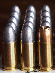 Close-up of uniform bullets with one copper hollow-point standing out—symbolizing superior...