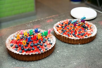 Berry birthday tarts with candles and decorations.