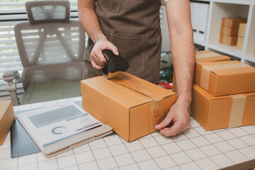 a small online business owner is checking boxes for accuracy before shipping to customers, parcel,...