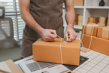 an employee is packing products into boxes to prepare for shipping to customers, a small online...