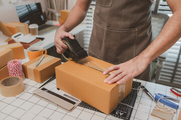 an employee is packing products into boxes to prepare for shipping to customers, a small online...