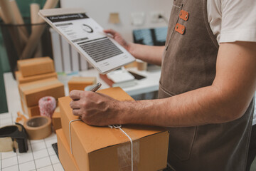 he is checking the boxes in the packing room, a small business owner is preparing boxes to ship to...