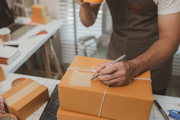 he is checking the boxes in the packing room, a small business owner is preparing boxes to ship to...