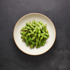 Edamame beans on black background, asian dish, top view