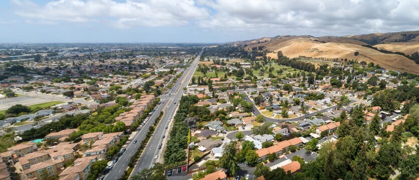 Aerial view of a residential area in Union City, California, USA, showcasing suburban living with houses, trees, and a road leading towards the hills.