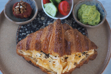 Cheese and veggie-filled croissant served