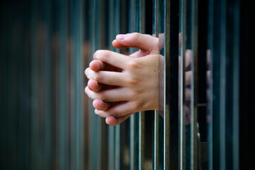 Hands Gripping Metal Bars in a Symbolic Representation of Confinement