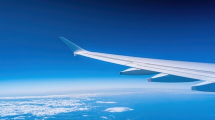 Obraz premium Airplane wing against blue sky