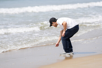 In early March, a Japanese man in his 30s spends time by the sea, standing on a sandy beach in the...