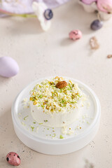 Pistachio tvorozhnaya pascha on white ceramic plate, bright natural light, overhead minimalist...