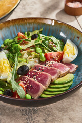nicoise salad with medium-rare seared tuna, bright natural lighting, shallow overhead composition