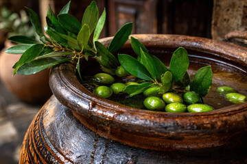 Olives soaking in brine inside a traditional ceramic jar