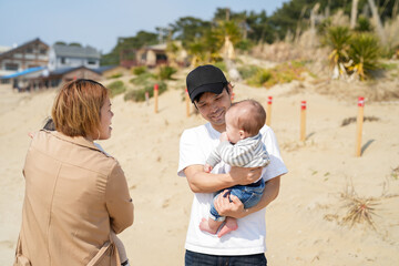 In early March, Japanese families enjoy the beach together: a 6-month-old baby, a 1-year-old girl, a 3-year-old girl, and parents in their 30s. A cheerful springtime scene filled with warmth and joy.