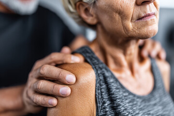 Fototapeta premium Mature woman receives treatment for shoulder pain
