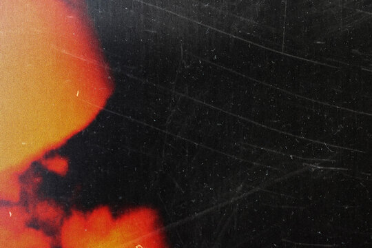 grungy black texture with vintage scratches and orange light leak for edgy web design, print media background, and creative branding graphics