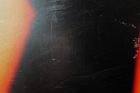 grungy black texture with vintage scratches and orange light leak for edgy web design, print media background, and creative branding graphics