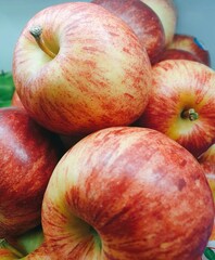 Close-up of vibrant red-streaked apples, showcasing juicy texture and natural sheen.