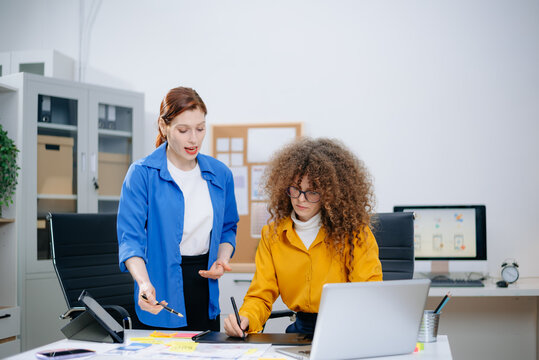 Two women discussing mobile app wireframes in a modern office. UX UI team collaboration, design thinking, and creative planning. - Powered by Adobe