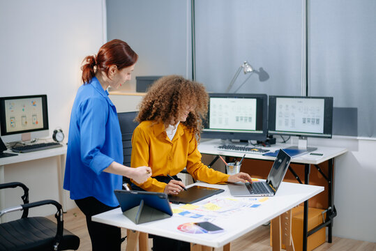 Creative UX UI design team collaborating on mobile interface in a bright tech office. Teamwork, planning, and modern workflow