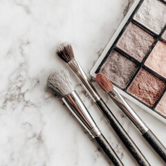 Makeup brushes and eyeshadow palette on marble (1)