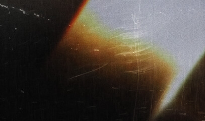 grainy colorful warm rainbow red blue light leaks on black background with dust texture. abstract...