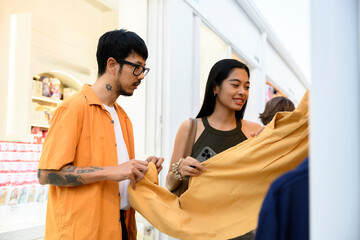 Young couple choosing clothes in fashion store
