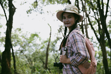Young female traveler with backpack walking in national park or forest. recreation sport in nature. Female person bag, wave for hiking journey in woods. adventure in forest. trekking with backpack